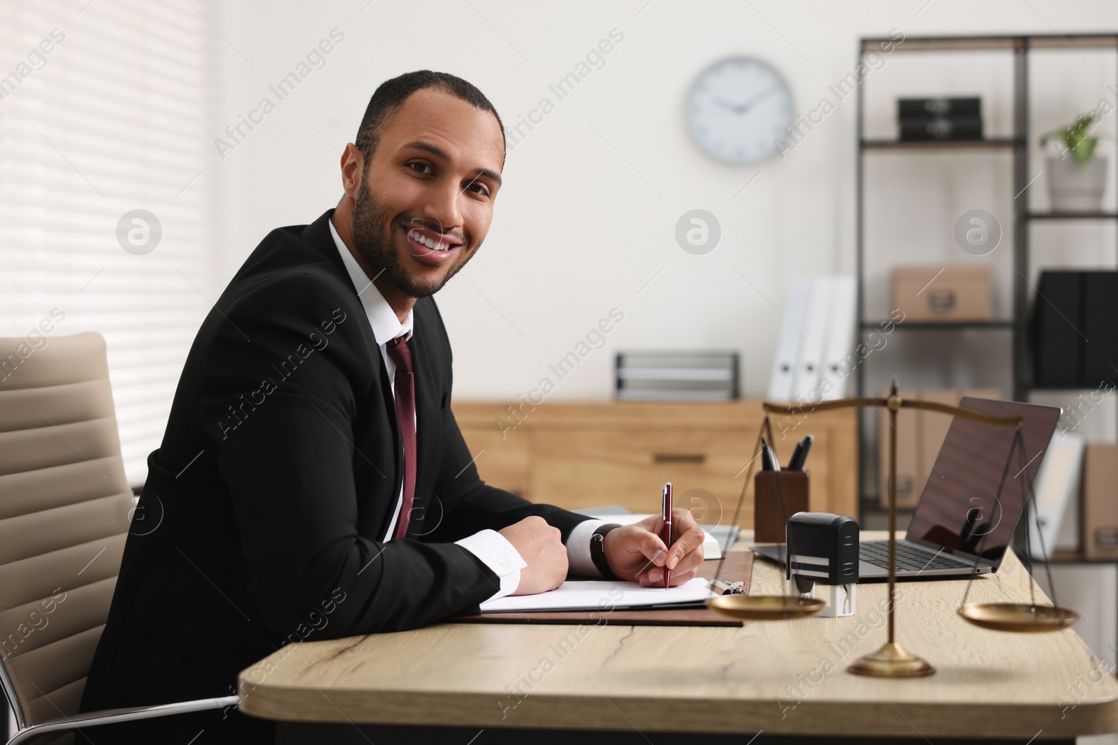 Photo of Portrait of smiling lawyer at table in office