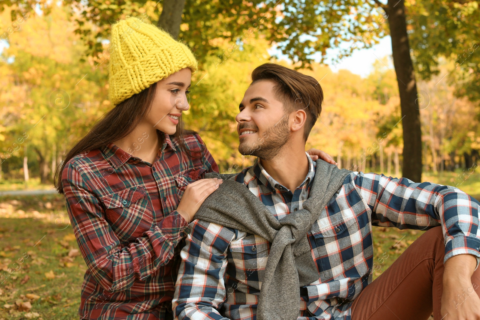 Photo of Young lovely couple spending time together in park. Autumn walk