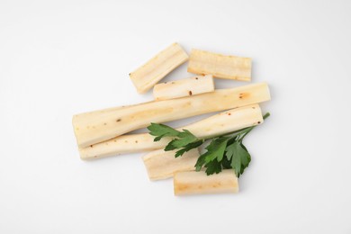 Photo of Cut raw salsify roots and parsley on white background, flat lay