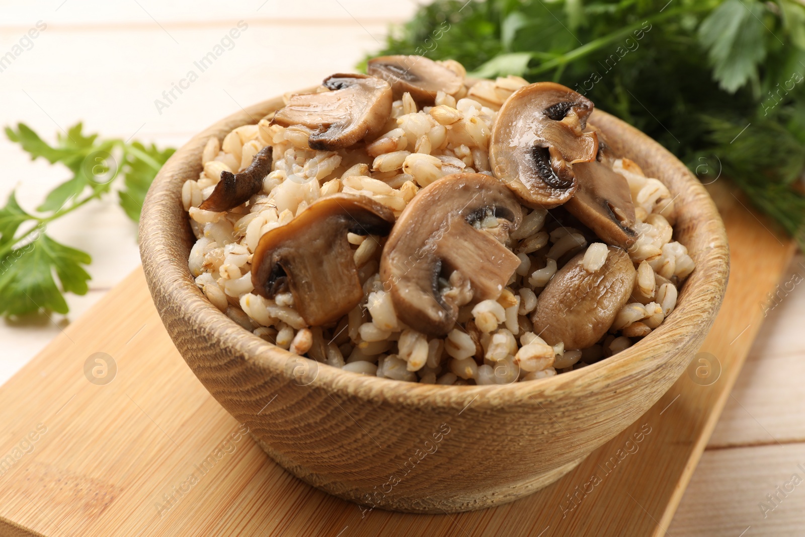 Photo of Delicious pearl barley with mushrooms on table, closeup