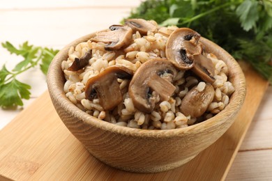 Photo of Delicious pearl barley with mushrooms on table, closeup