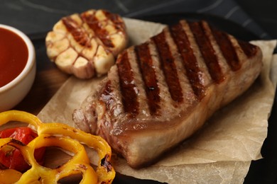 Photo of Delicious grilled beef steak with vegetables on table, closeup