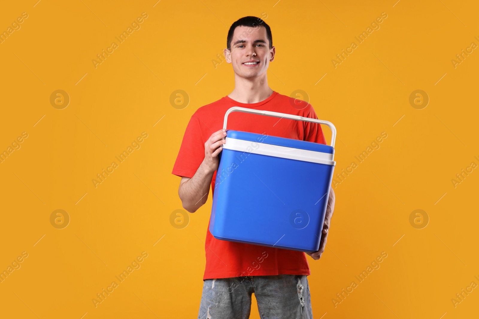 Photo of Man with blue cool box on orange background