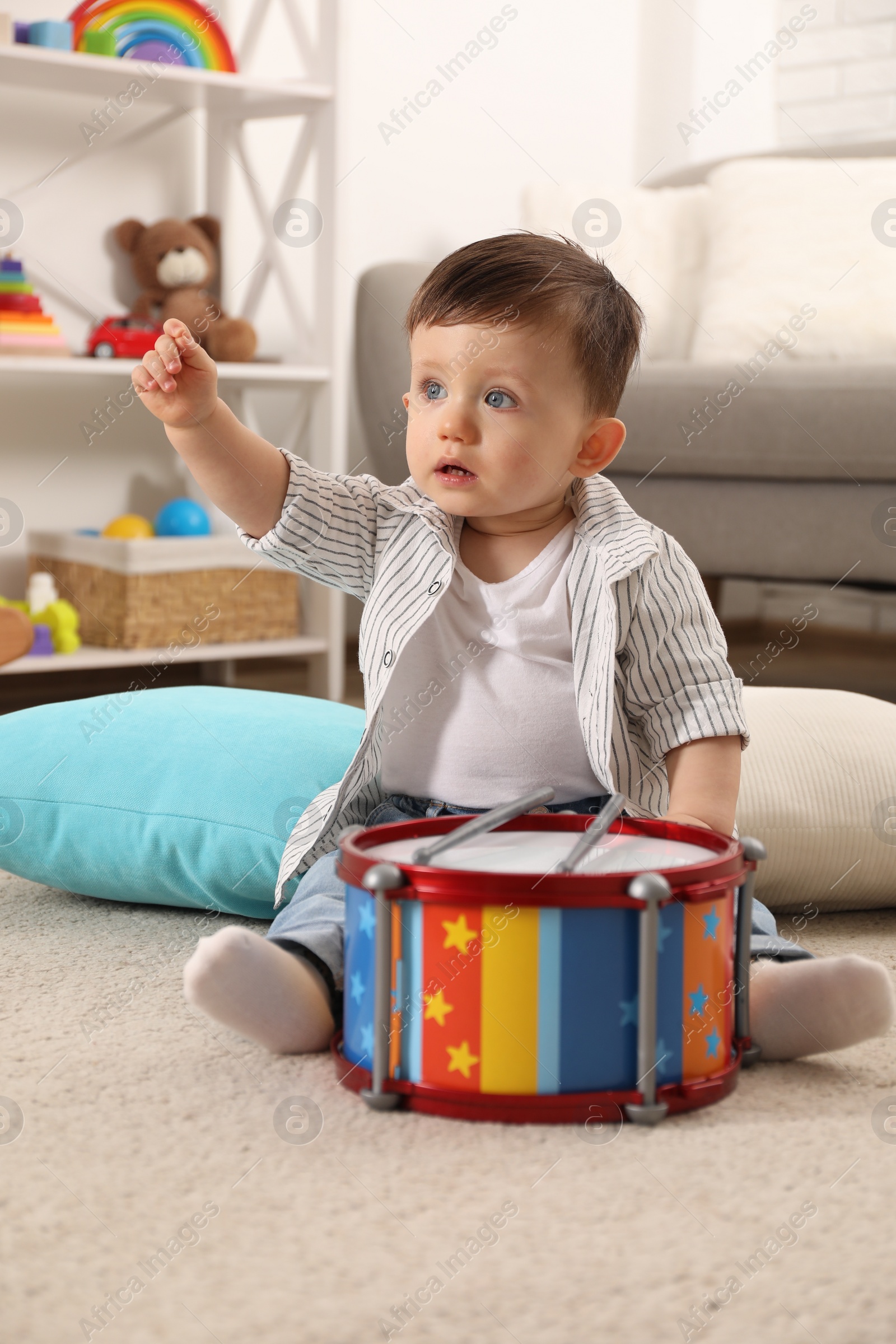 Photo of Cute little boy with toy drum at home