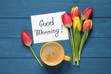 Photo of Message GOOD MORNING, tulips and coffee on blue  wooden table, flat lay