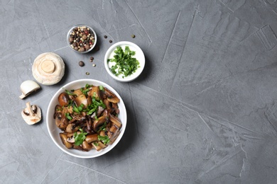 Photo of Flat lay composition with bowl of fried mushrooms and space for text on grey background