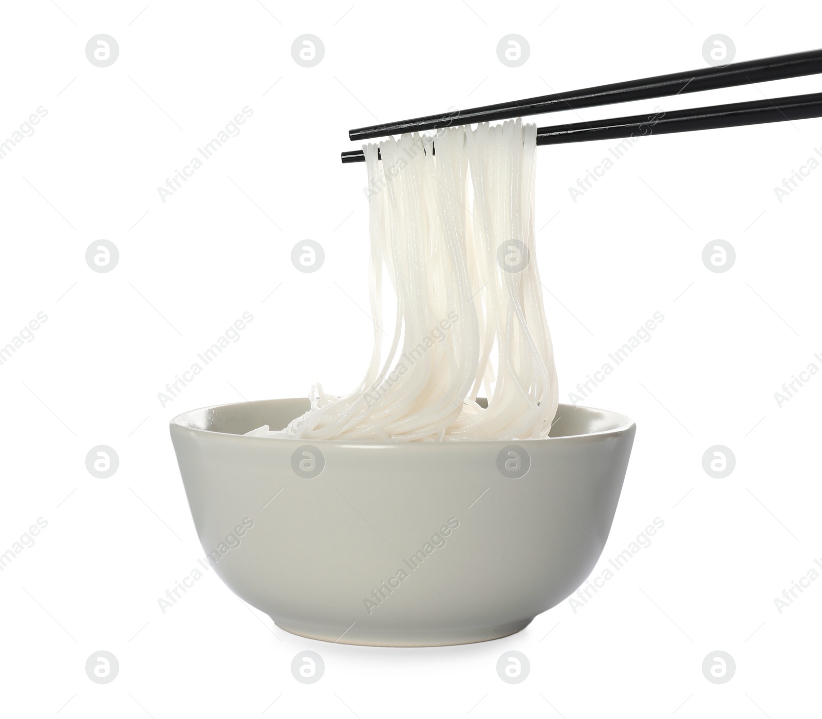 Photo of Chopsticks with cooked rice noodles over bowl isolated on white