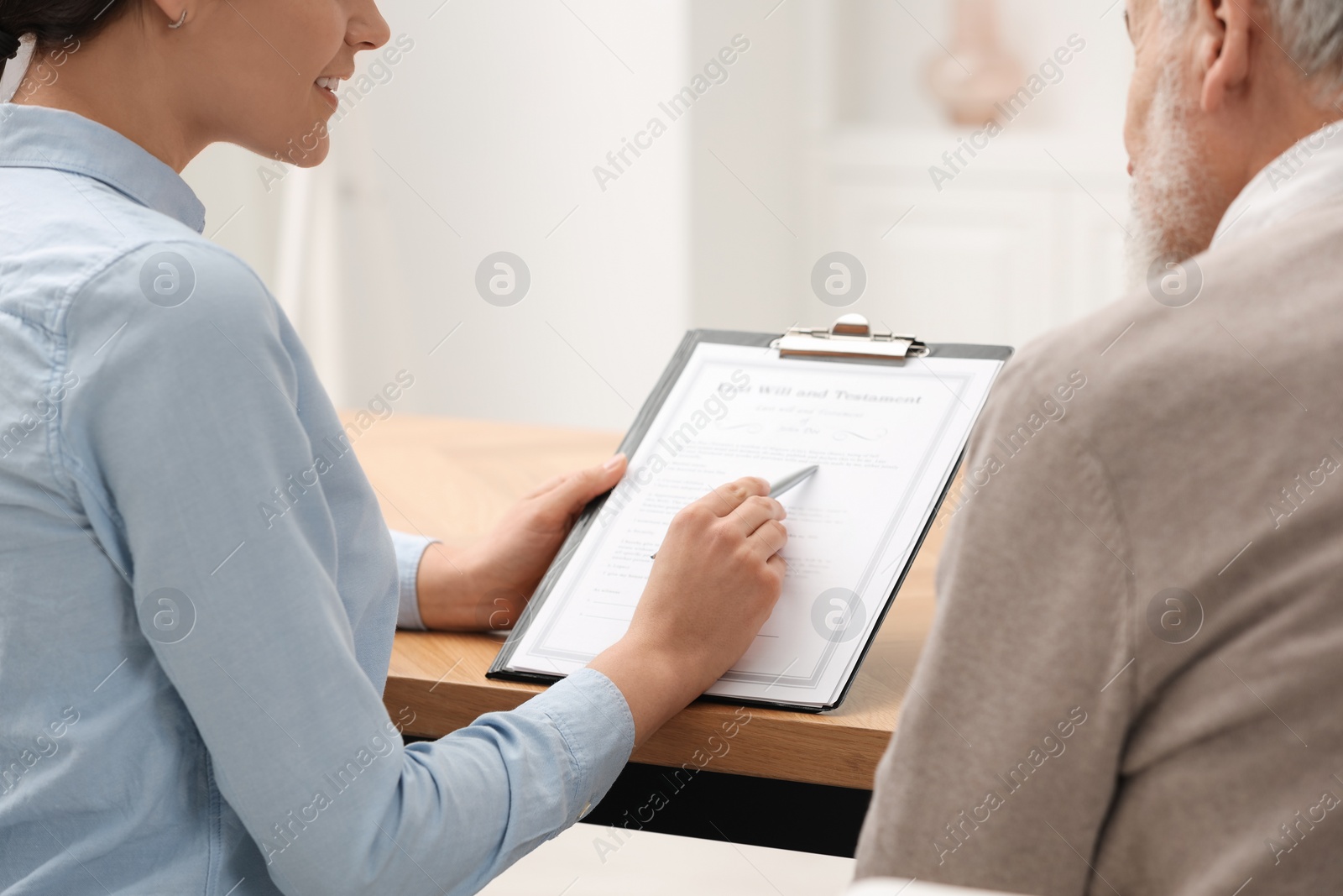 Photo of Notary consulting senior man about Last Will and Testament in office, closeup