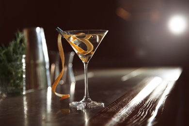 Glass of lemon drop martini cocktail on bar counter. Space for text