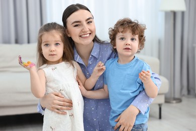 Photo of Mother and her little children with painted hands at home