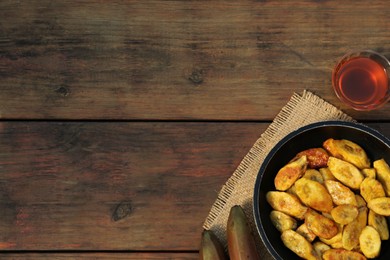 Flat lay composition with deep fried banana slices on wooden table. Space for text