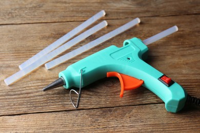 Photo of Hot glue gun and sticks on wooden table