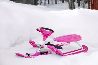 Photo of Stylish pink snow scooter outdoors. Winter season