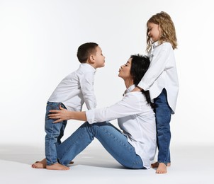 Little children with their mother on white background