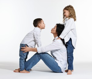 Photo of Little children with their mother on white background