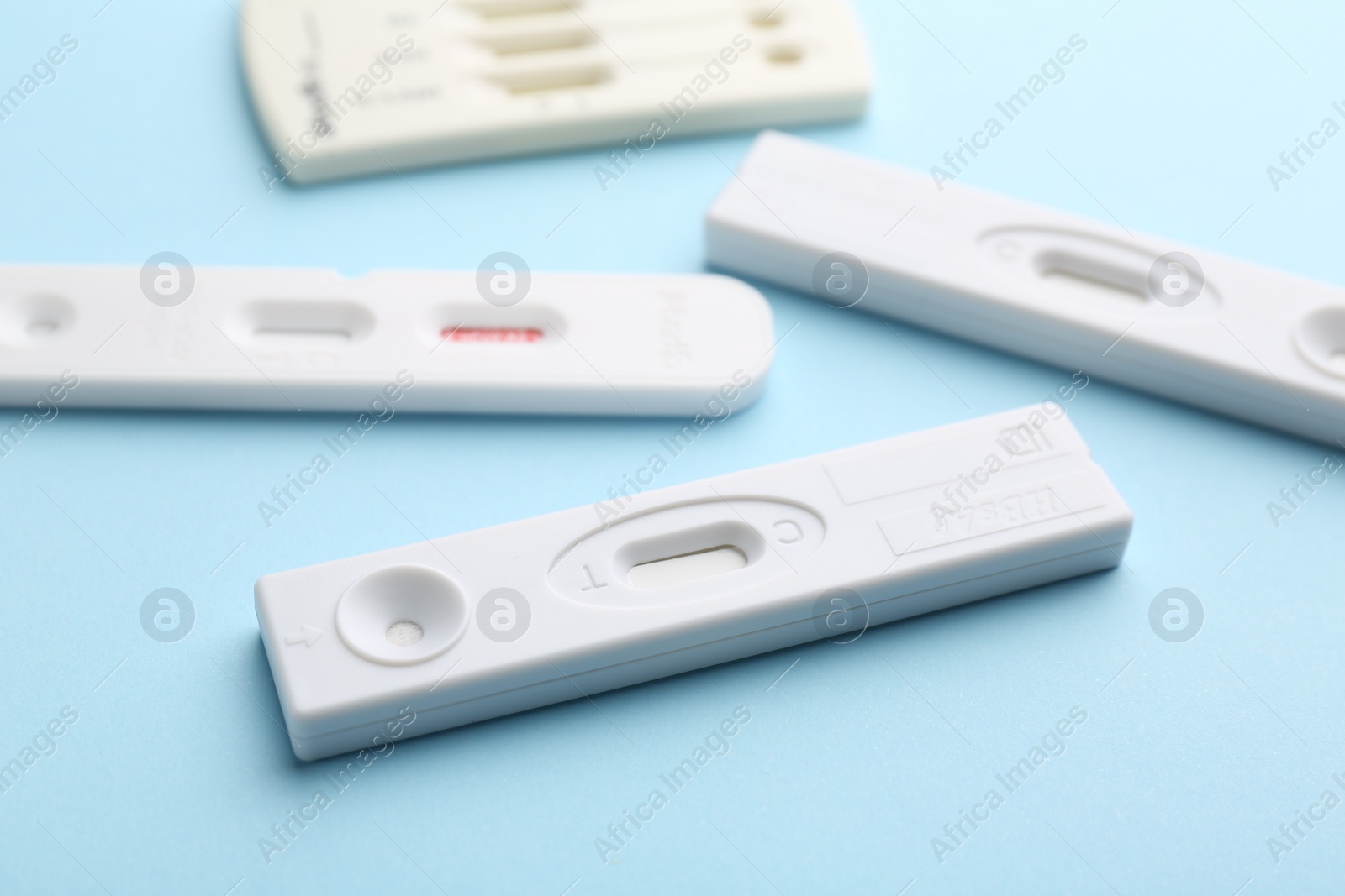 Photo of Different disposable express tests on light blue background