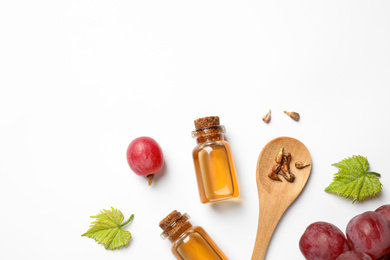 Photo of Composition with bottles of natural grape seed oil on white background, top view. Organic cosmetic