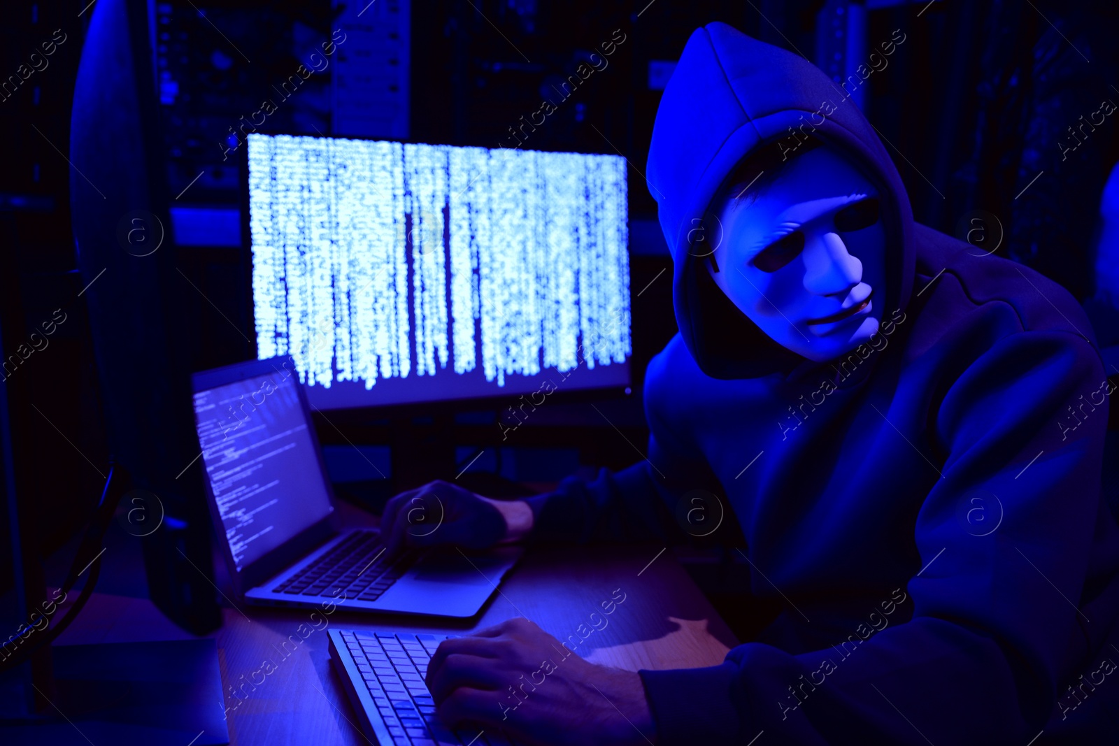 Photo of Hacker working with computers in dark room. Cyber attack