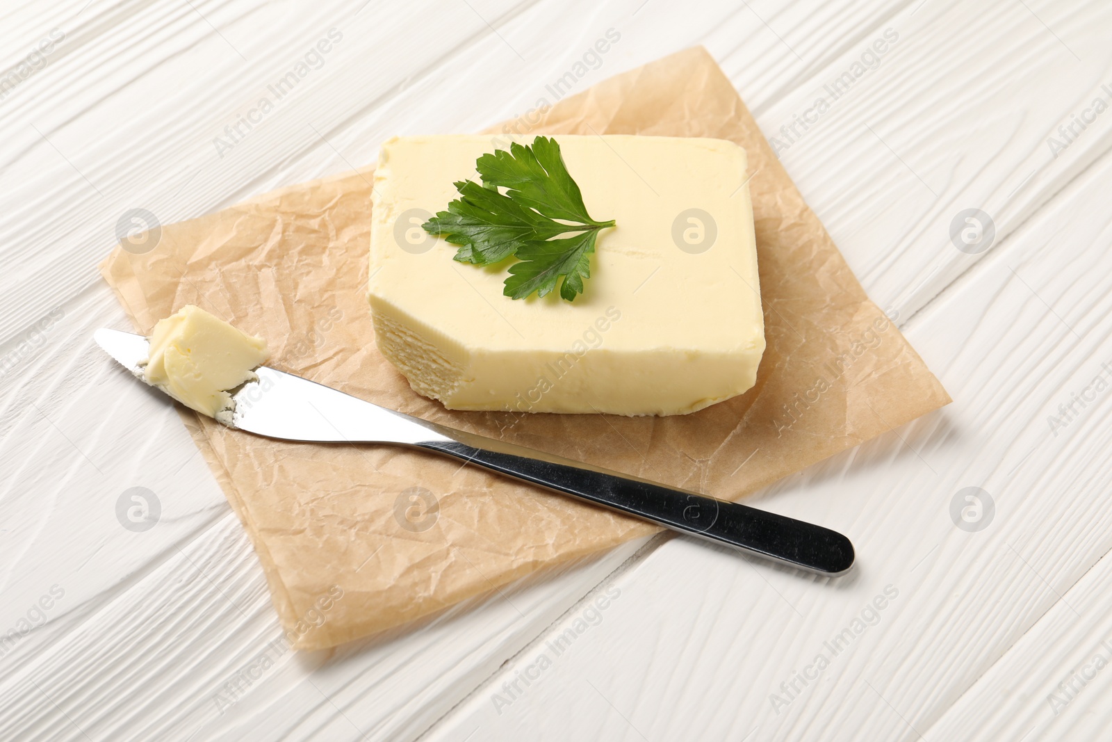 Photo of Tasty butter and knife on white wooden table