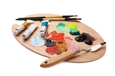 Photo of Wooden palette with oil paints and tools on white background