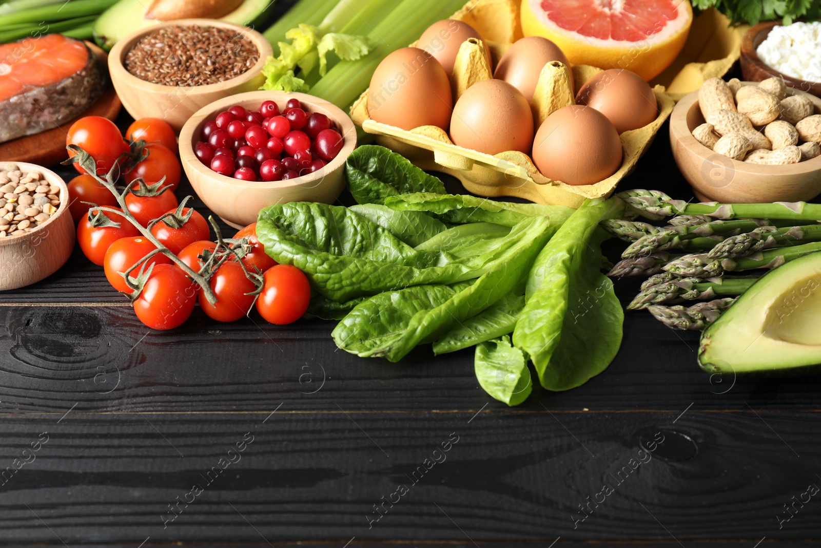 Photo of Many different healthy food on black wooden table. Space for text