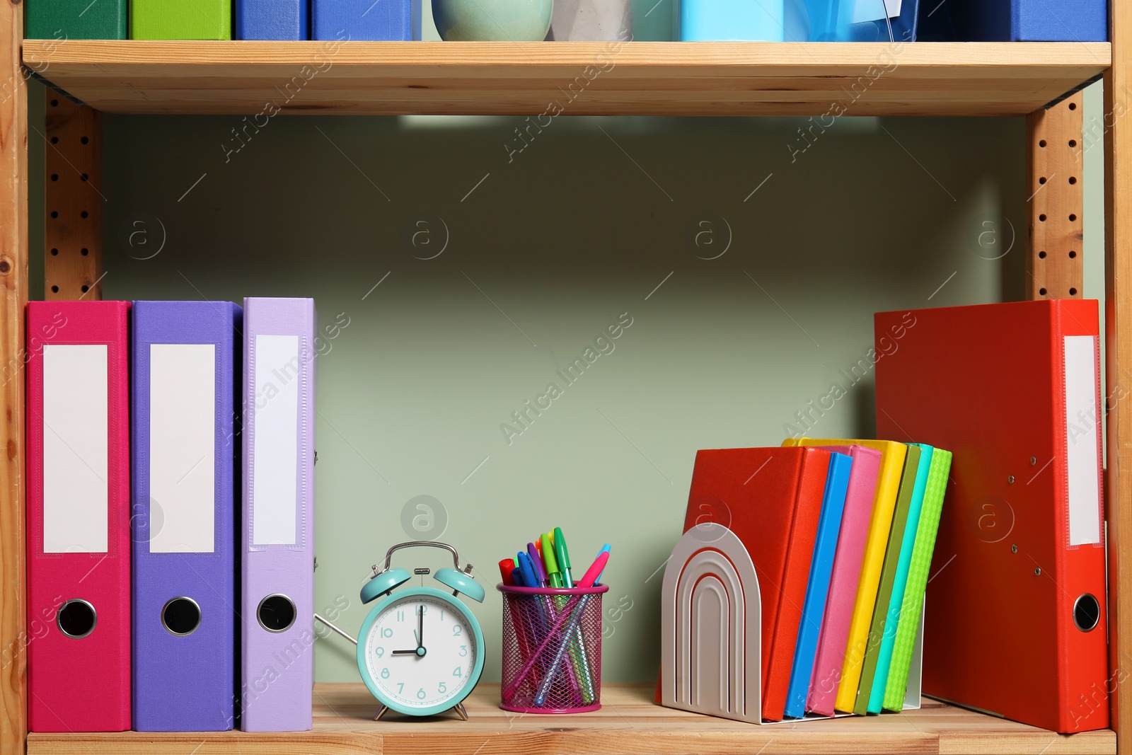 Photo of Colorful binder office folders and stationery on shelving unit indoors