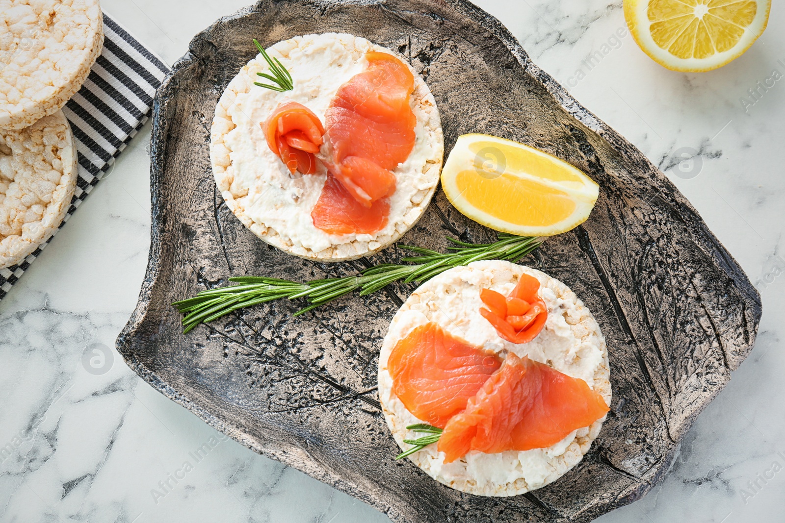 Photo of Plate of crispbreads with fresh sliced salmon fillet on table, top view