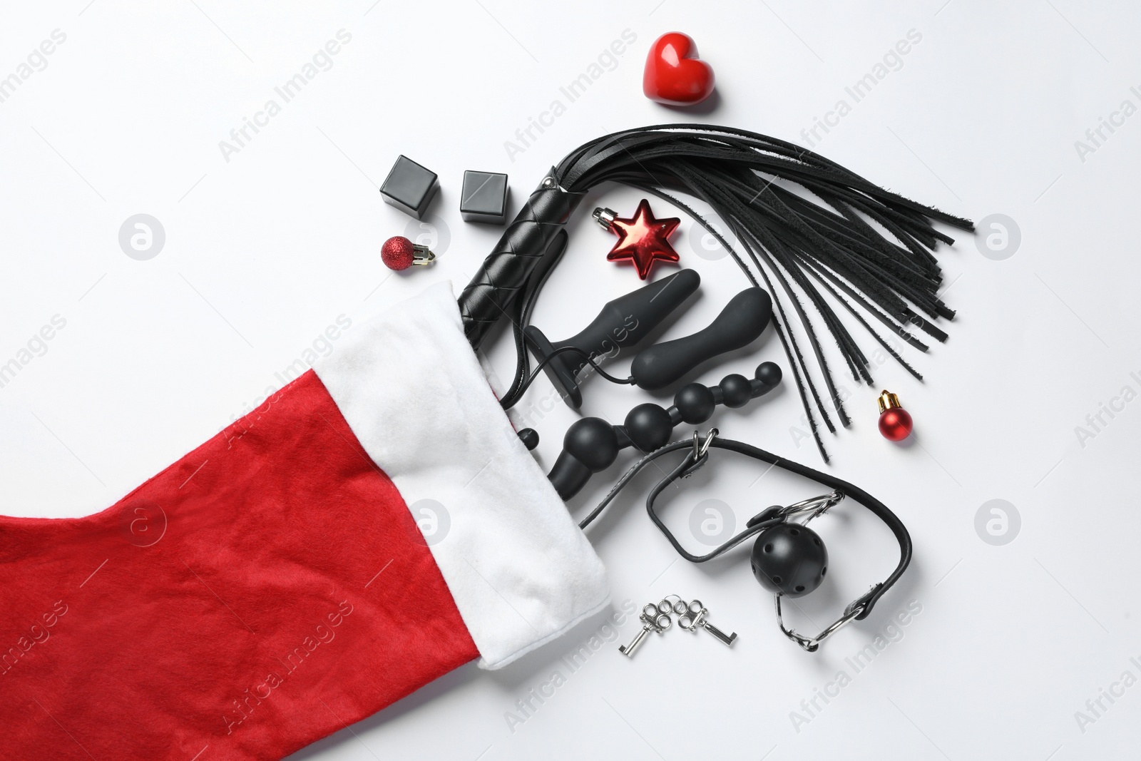 Photo of Christmas stocking with different sex toys on white background, top view