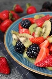 Photo of Plate of delicious fresh fruit salad on table, closeup