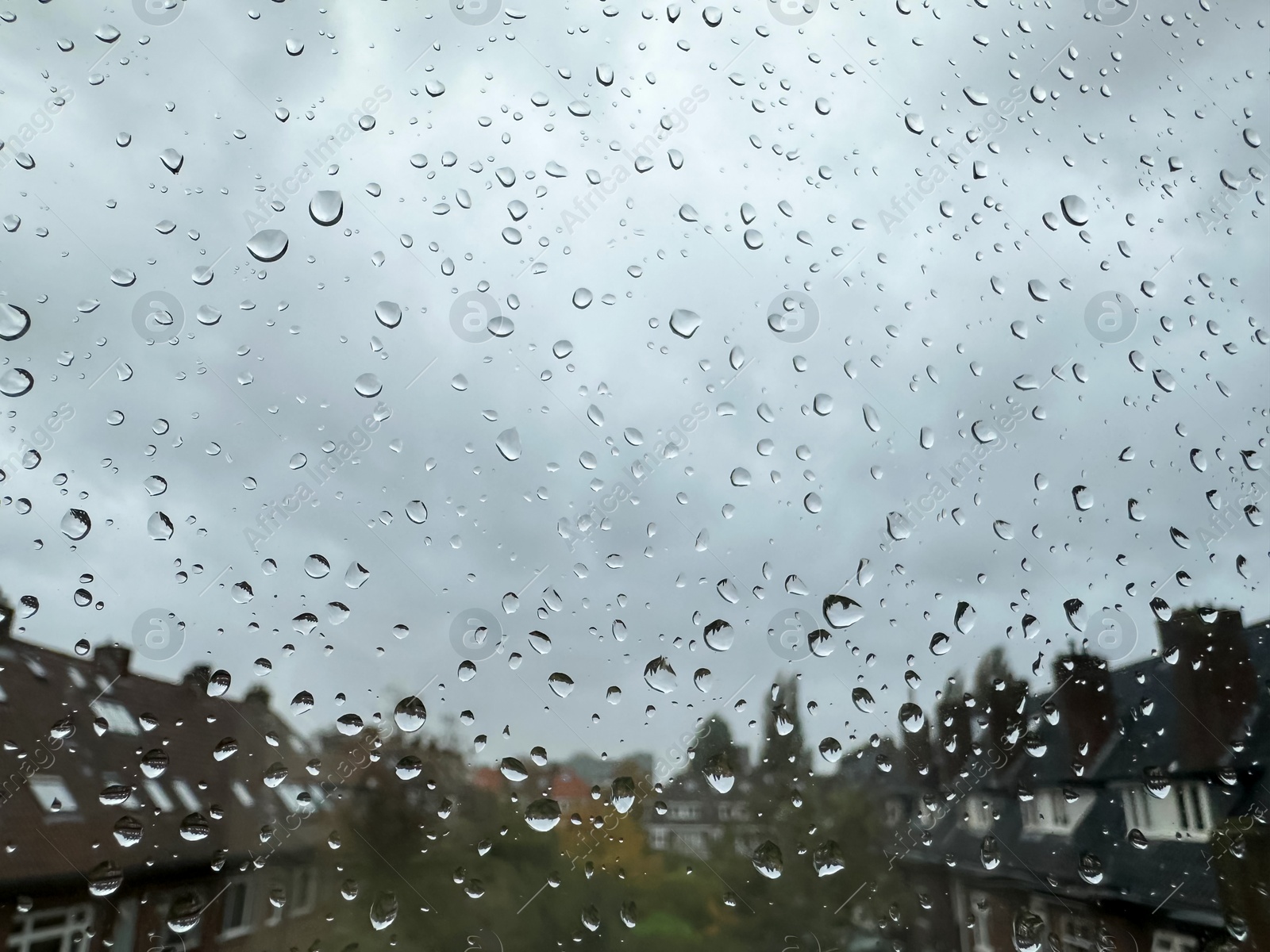 Photo of Window with water droplets on rainy day, closeup