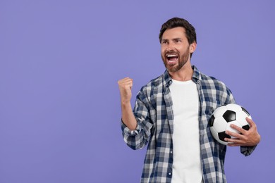 Emotional sports fan with soccer ball on purple background. Space for text