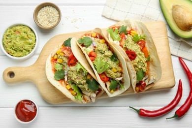 Photo of Delicious tacos with guacamole, meat and vegetables on white wooden table, flat lay