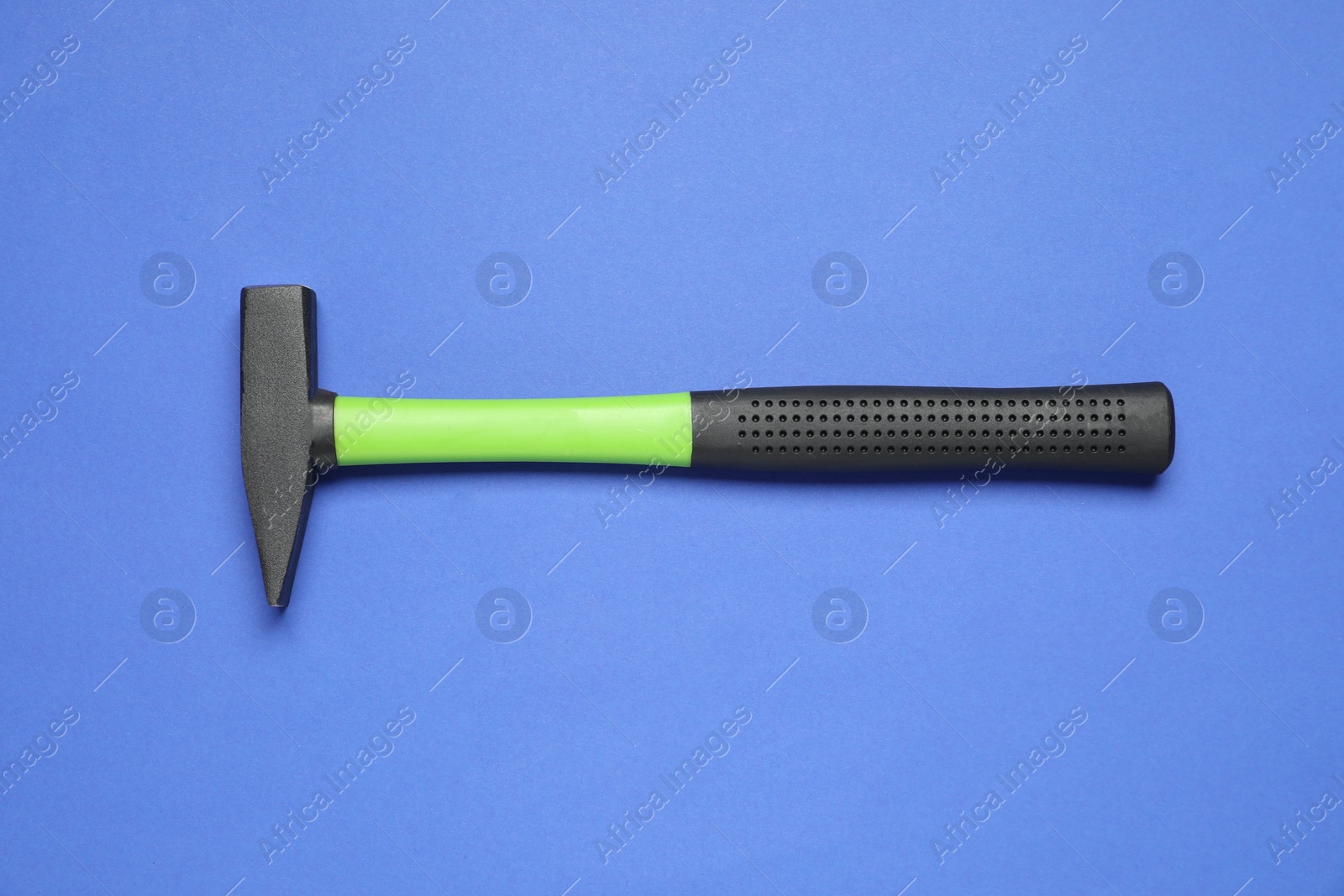 Photo of New hammer with rubber handle on blue background, top view