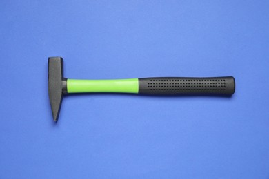 Photo of New hammer with rubber handle on blue background, top view