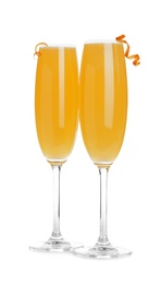 Photo of Fresh alcoholic Mimosa cocktails decorated with orange peels on white background