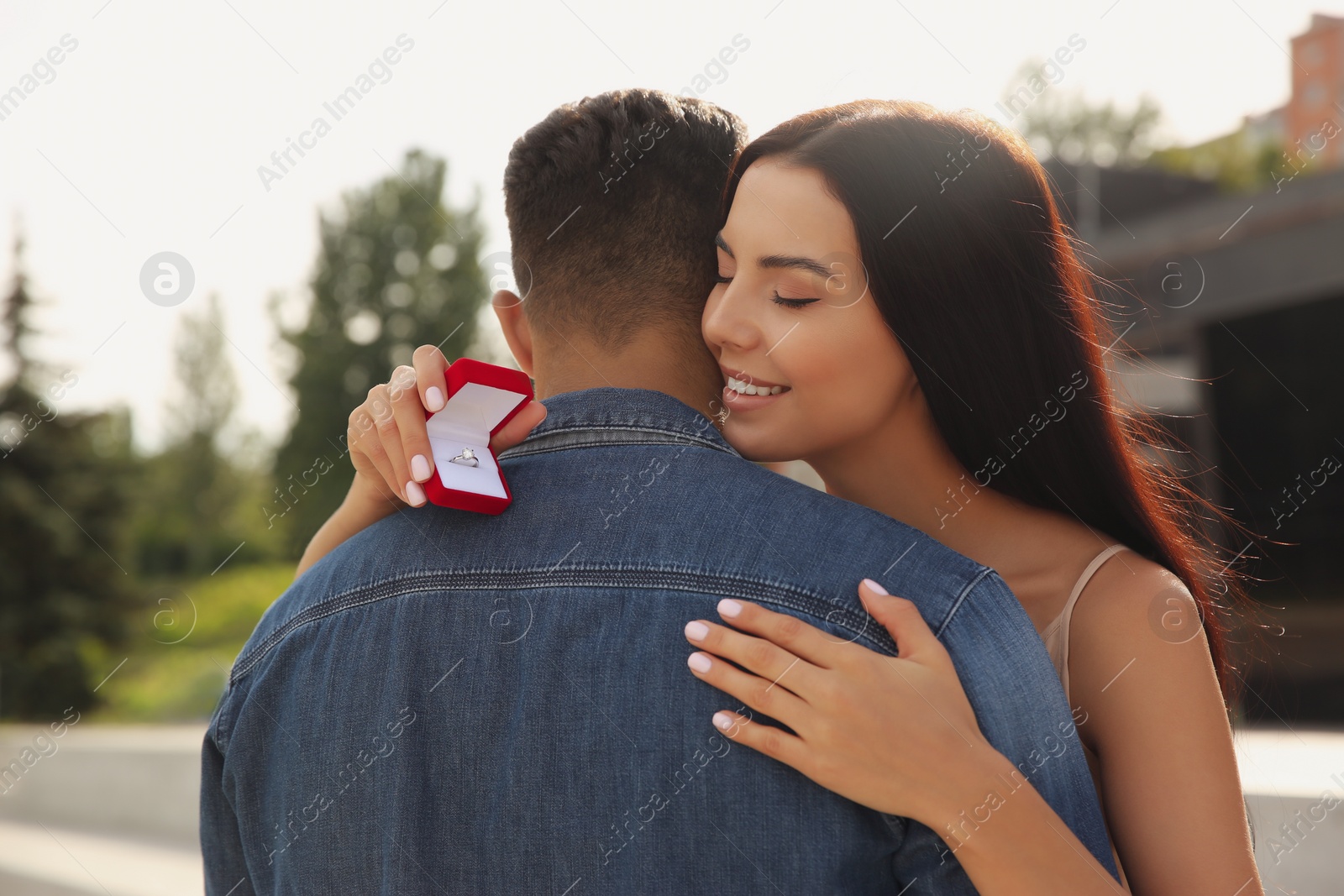 Photo of Man with engagement ring making proposal to his girlfriend outdoors