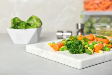 Photo of Board with mix of frozen vegetables on table