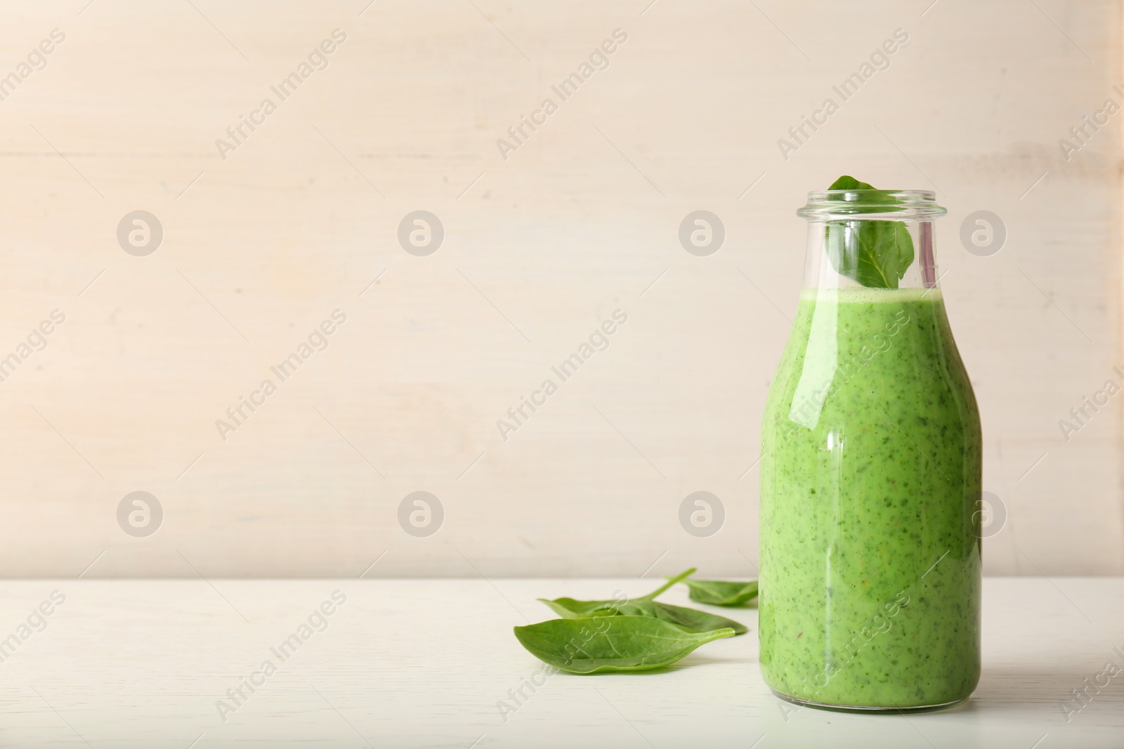 Photo of Bottle with delicious detox smoothie on table