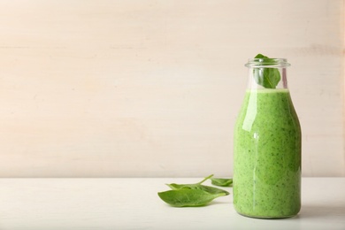 Photo of Bottle with delicious detox smoothie on table