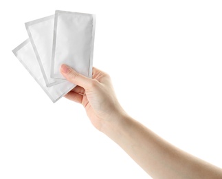 Photo of Woman holding medicine sachets on white background, closeup