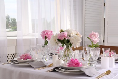 Stylish table setting with beautiful peonies in dining room