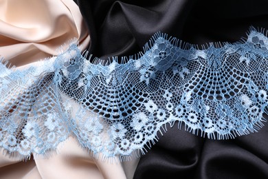 Beautiful light blue lace on color fabrics, top view