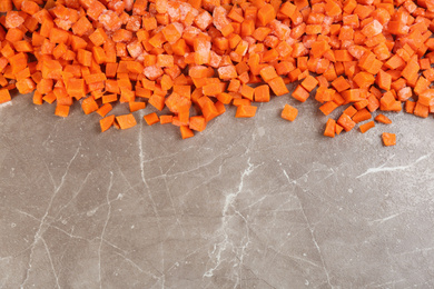 Photo of Frozen carrots on brown marble table, top view with space for text. Vegetable preservation