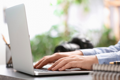 Journalist working with laptop at table, closeup