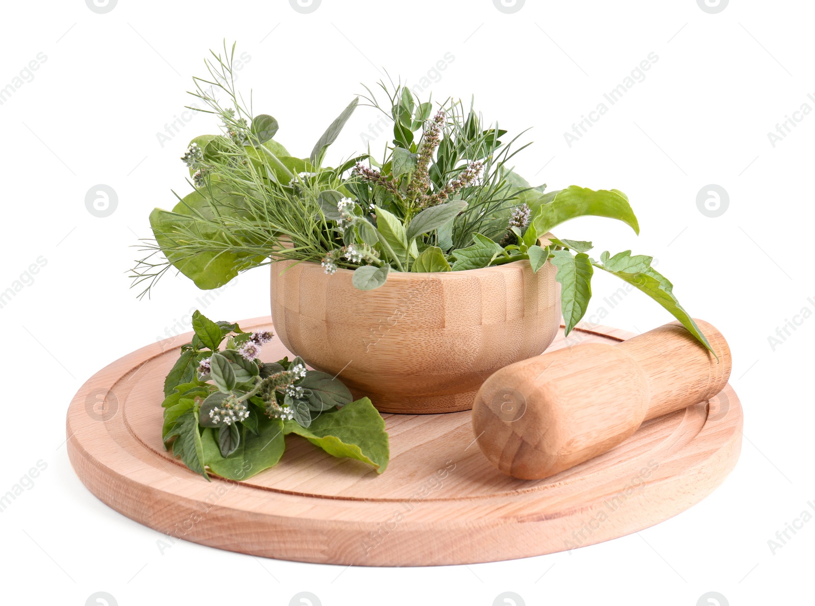 Photo of Wooden board and mortar with different herbs, flowers and pestle on white background