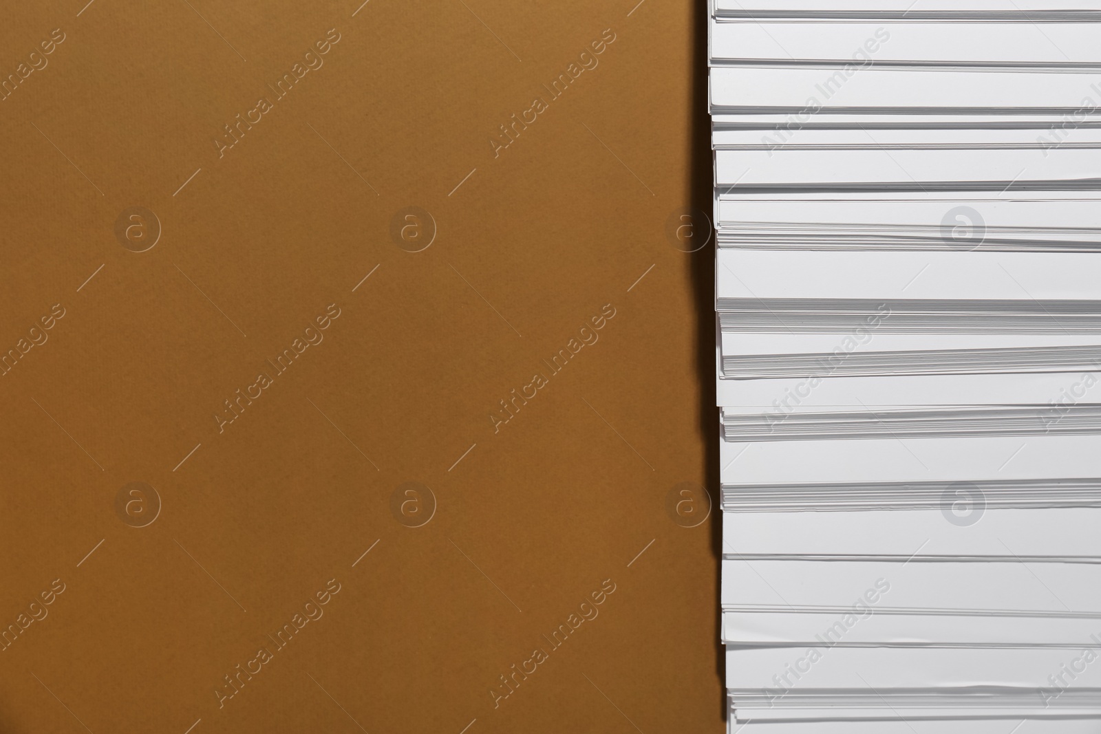 Photo of White paper sheets on brown background, flat lay. Space for text