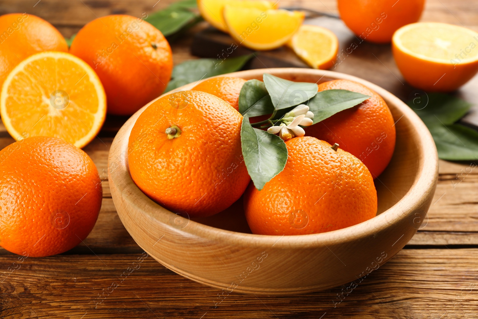 Photo of Delicious ripe oranges on wooden table, closeup
