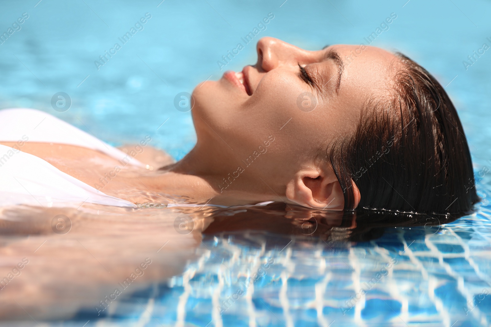 Photo of Beautiful young woman relaxing in outdoor swimming pool