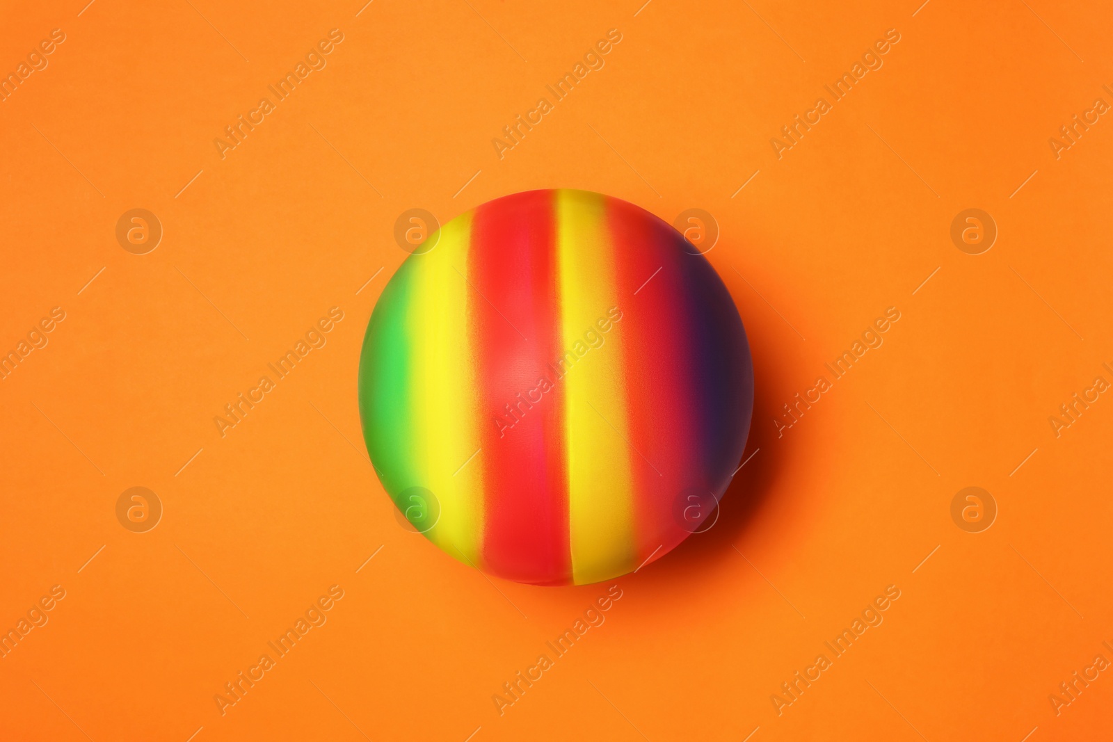 Photo of New bright kids' ball on orange background, top view