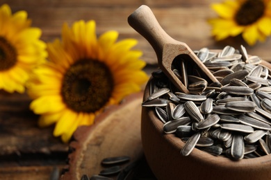 Photo of Raw sunflower seeds in bowl on table, closeup